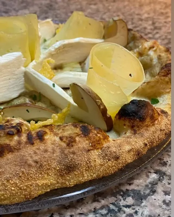 Pizza bianca con carciofi, patate e formaggio a fette.